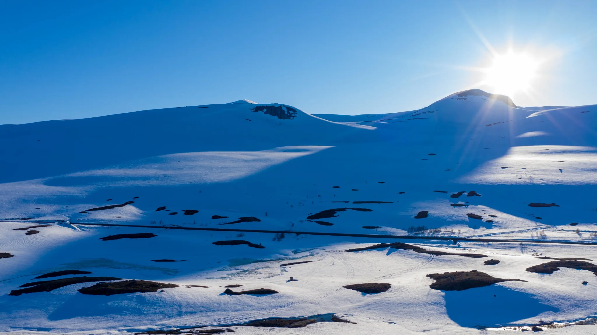 Sol over snødekt fjell