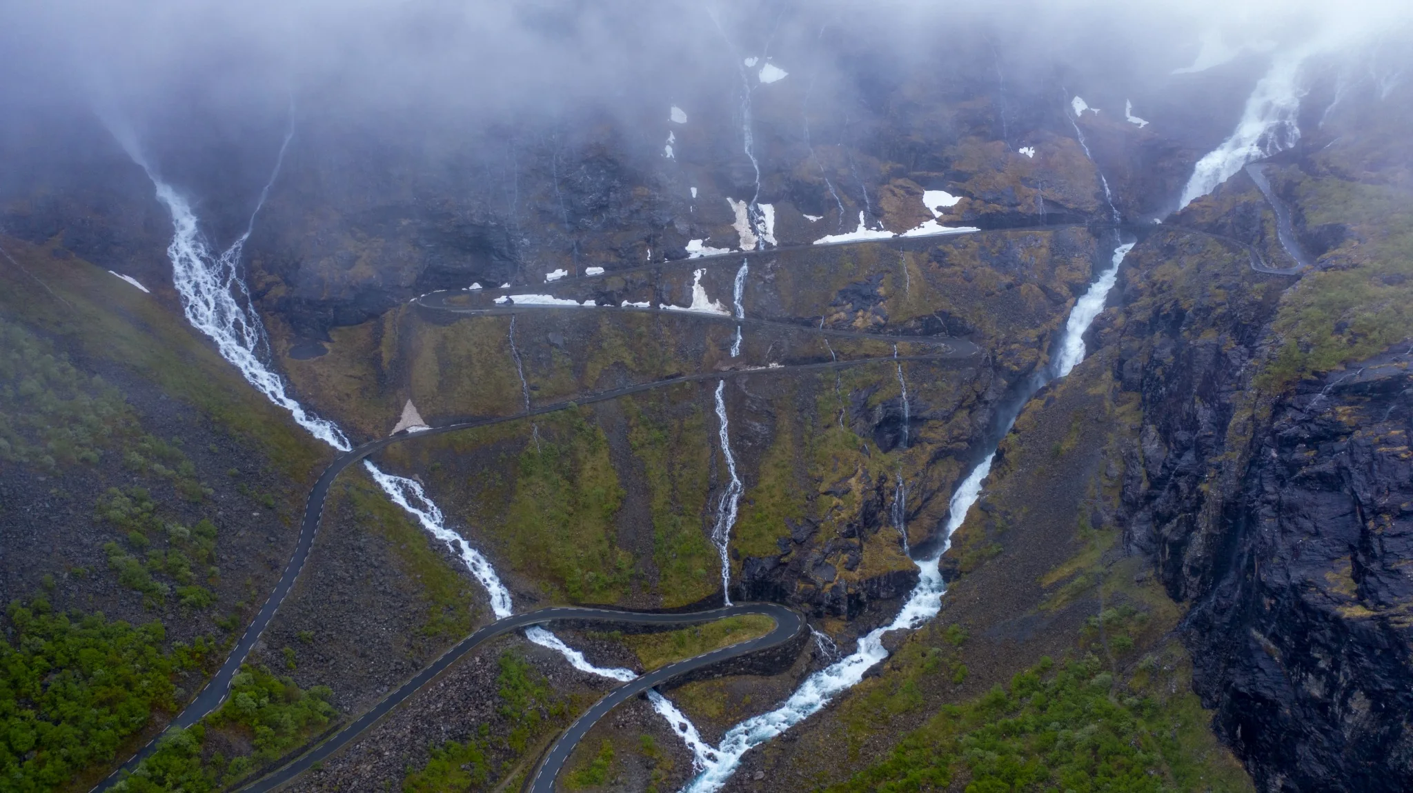Svingete fjellvei med fossefall